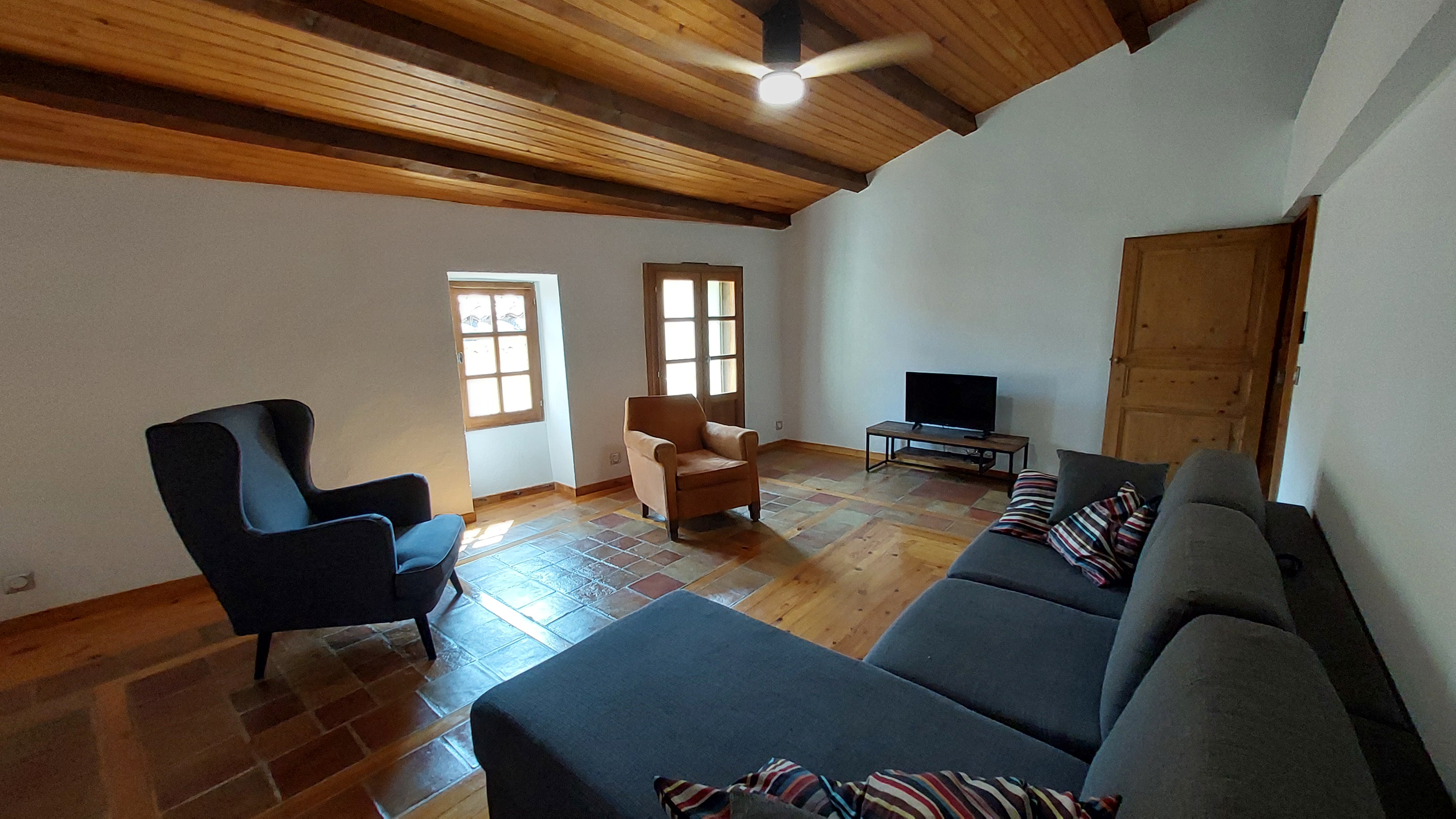 Séjour du gîte, avec TV WIFI et canapé convertible, vue des 2 fenêtres qui font rentrer la lumière